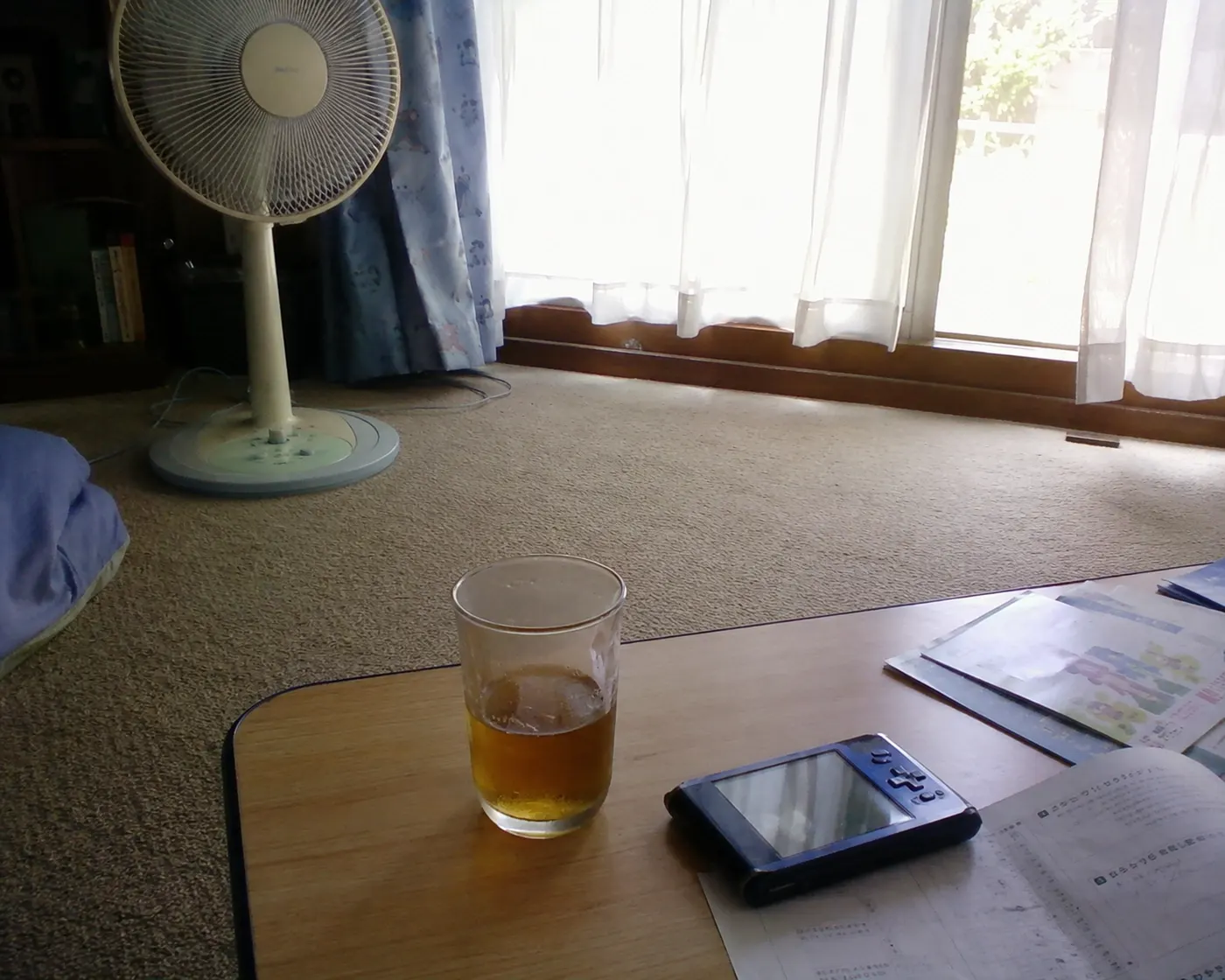 夏休みの部屋と机の上の麦茶、携帯ゲーム機